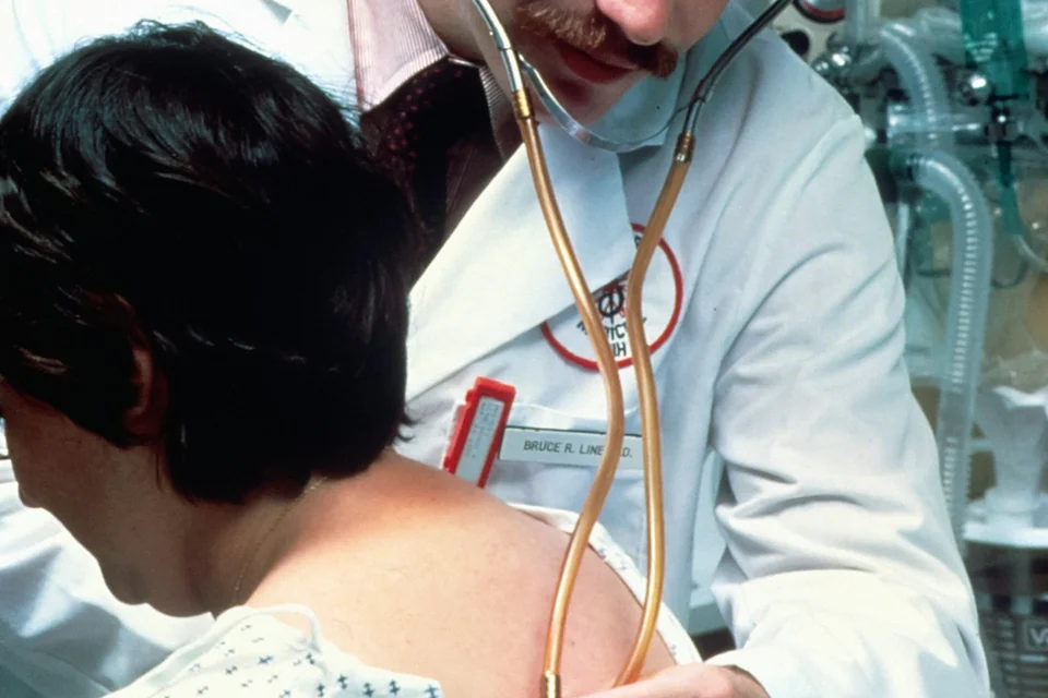 Un professionista sanitario visita una paziente con lo stetoscopio