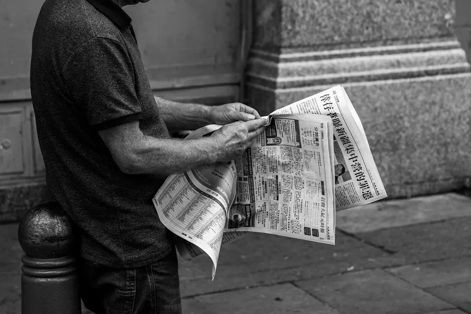 Un lettore con il giornale in una strada cittadina