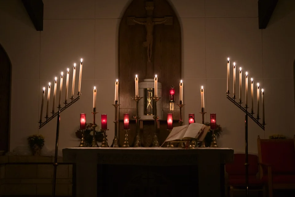 Candele accese e crocifisso all'interno di una chiesa